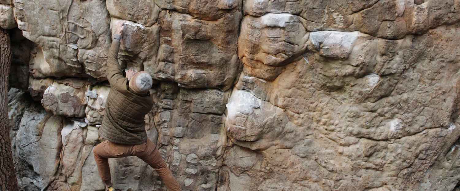 Avila Climbing Co. chalk kits laid out at the base of a boulder