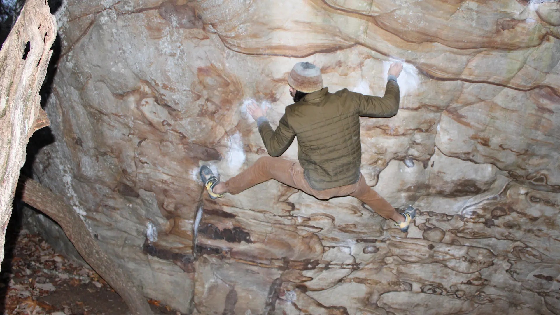 Climber on rock face using Grippa climbing chalk for grip and confidence