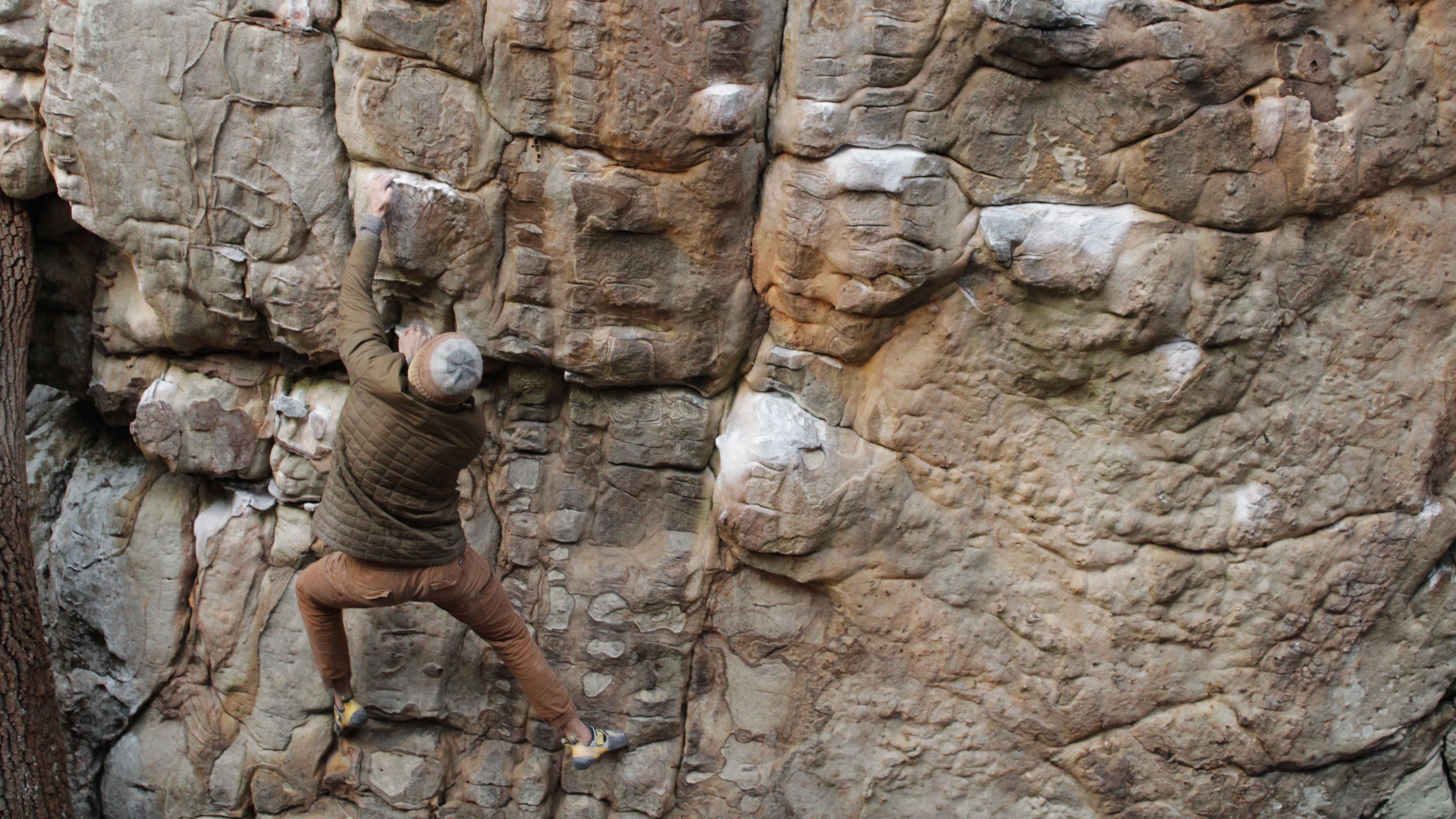 Person climbing a rocky cliff face