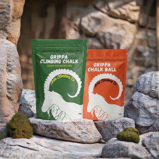 Two Grippa Climbing Chalk packages on rocks with a rocky background