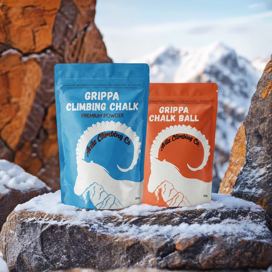 Two packages of Grippa Climbing Chalk on a rock with a mountainous background