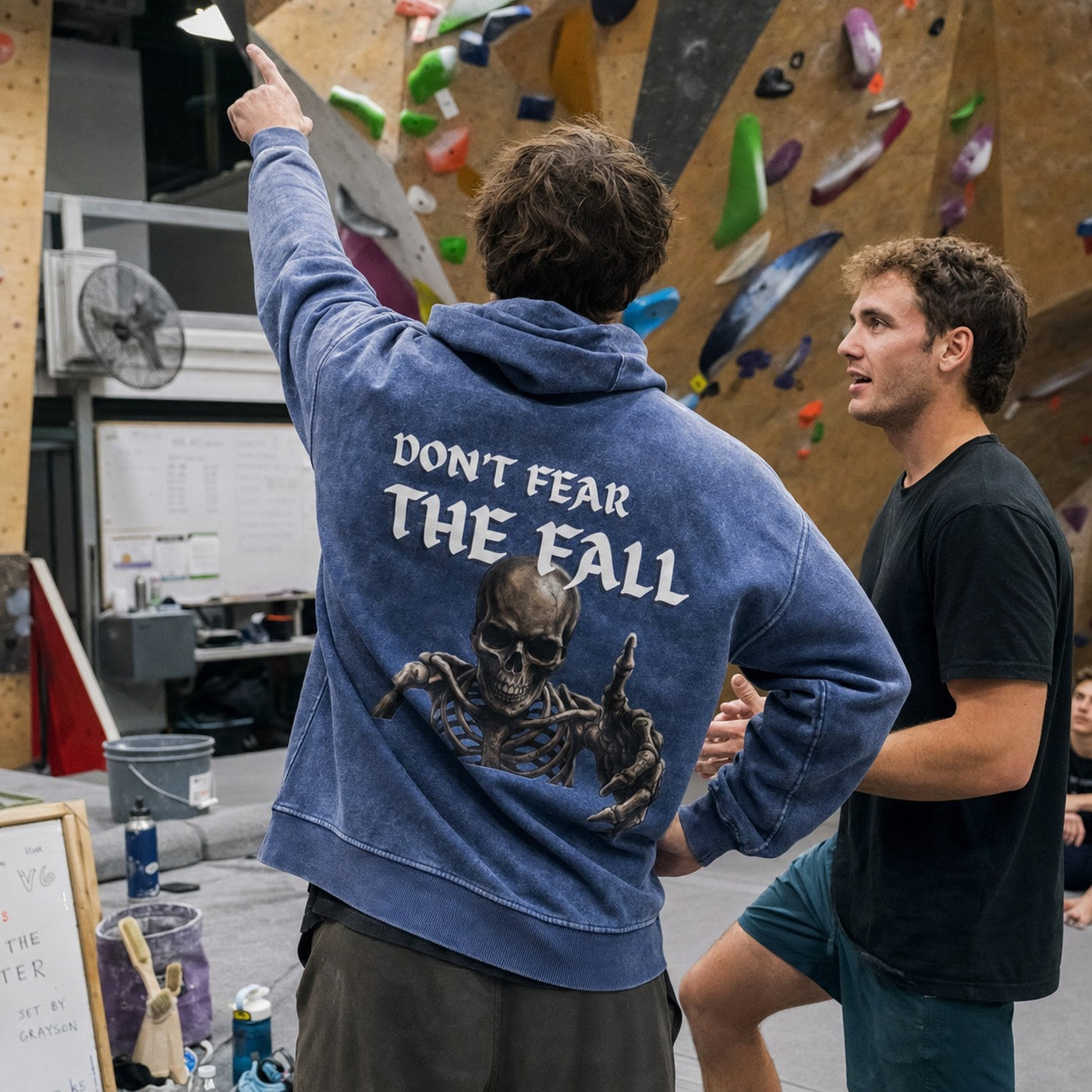 Avila Climbing Co. Dead Point Hoodie worn while reading a boulder problem in the gym