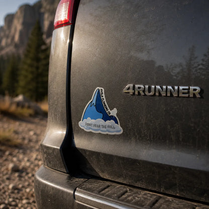 A die-cut vinyl sticker applied to the rear left side of a dark gray 4Runner vehicle, featuring a blue shark jumping out of water with the text 'DON'T FEAR THE FALL' and 'Avila Climbing Co' on the side.